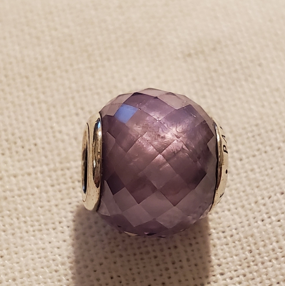 2 Pandora beads one purple and one pink.